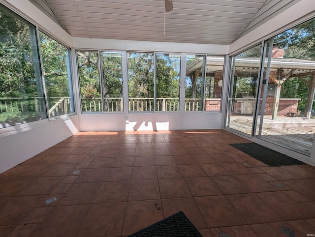 unfurnished sunroom featuring a wealth of natural light and vaulted ceiling