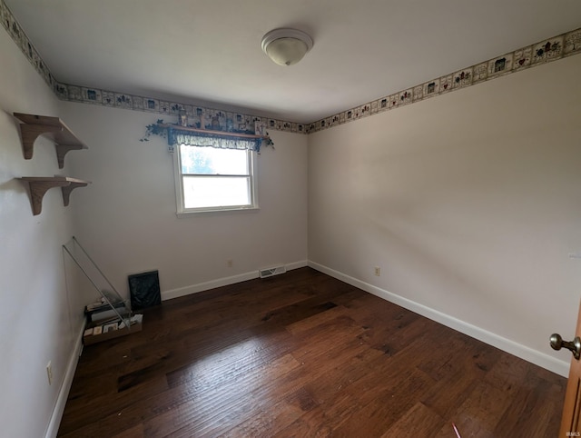 unfurnished room with dark wood-type flooring