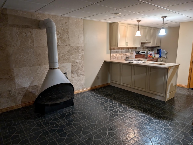 kitchen featuring electric range, a wood stove, kitchen peninsula, a paneled ceiling, and decorative light fixtures