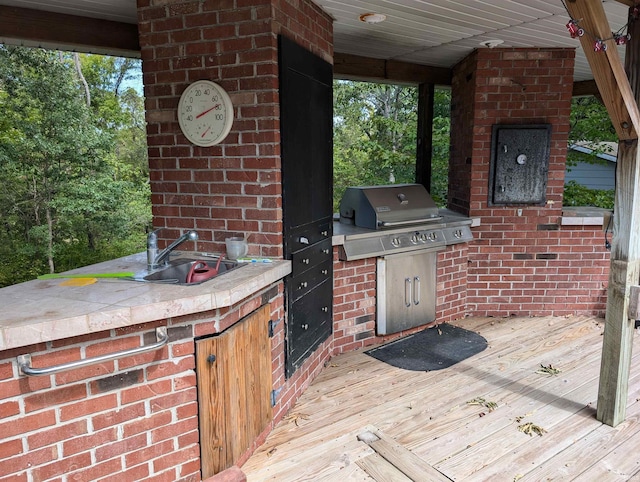 view of patio featuring area for grilling, sink, a wooden deck, and a grill