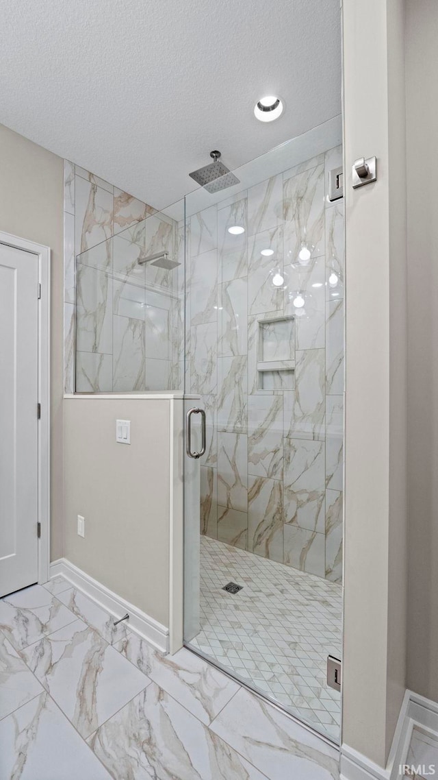 bathroom with walk in shower and a textured ceiling