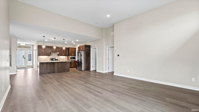 unfurnished living room featuring hardwood / wood-style floors and a high ceiling