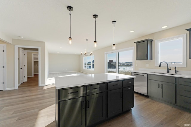 kitchen featuring light countertops, light wood-style floors, dishwasher, and a sink