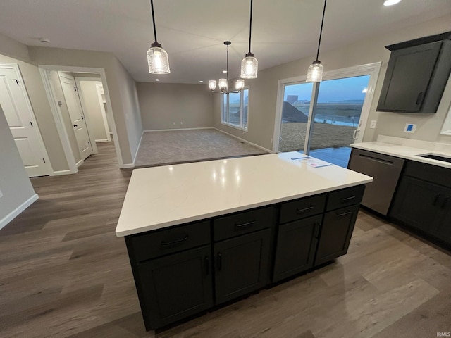 kitchen with a kitchen island, decorative light fixtures, dark hardwood / wood-style flooring, sink, and stainless steel dishwasher