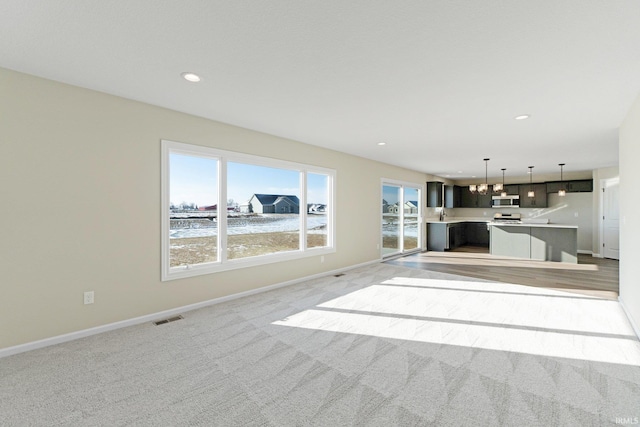 unfurnished living room with light colored carpet, baseboards, visible vents, and recessed lighting