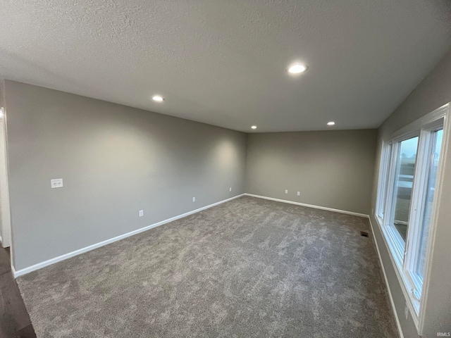 carpeted empty room with a textured ceiling