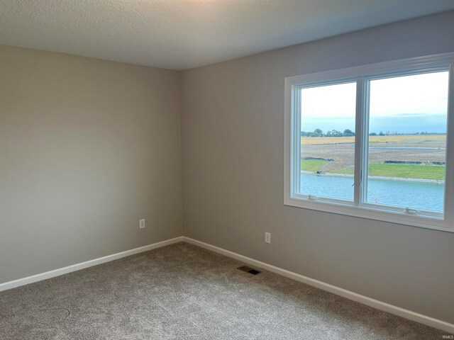 empty room with a rural view and carpet floors