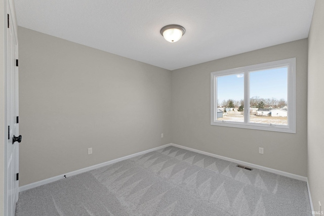 unfurnished room with light carpet, visible vents, and baseboards