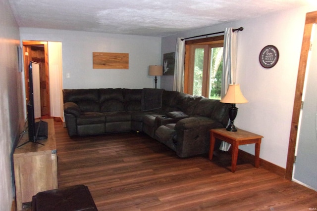 living room featuring a textured ceiling and dark wood-type flooring