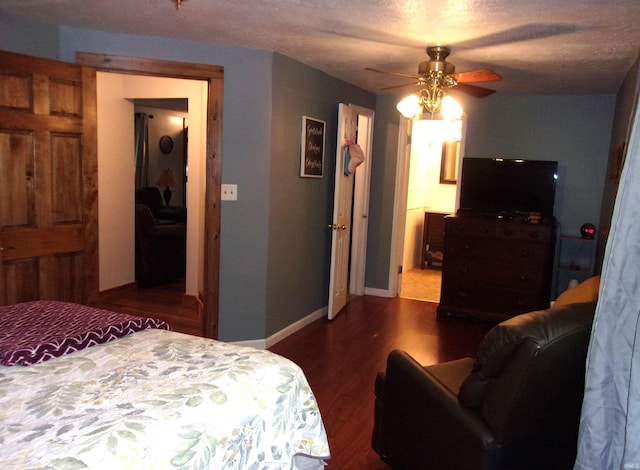 bedroom featuring ceiling fan, dark hardwood / wood-style floors, and a textured ceiling