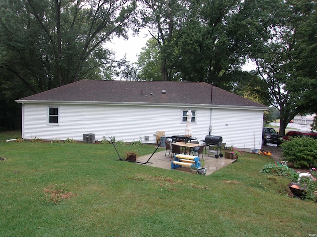 back of house with a patio, a lawn, and central AC