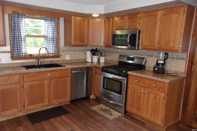 kitchen featuring dark hardwood / wood-style flooring, decorative backsplash, appliances with stainless steel finishes, and sink