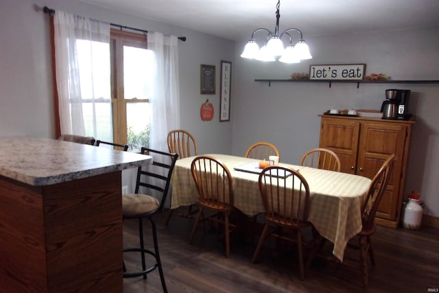 dining area featuring an inviting chandelier and dark wood-type flooring