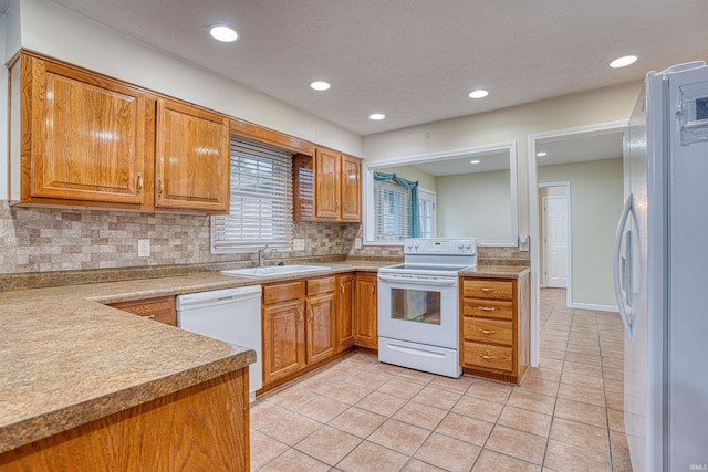 kitchen with light tile patterned floors, sink, white appliances, and tasteful backsplash