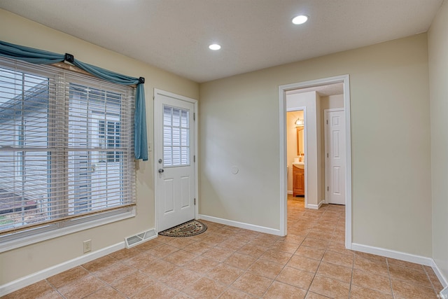 tiled entrance foyer with a textured ceiling