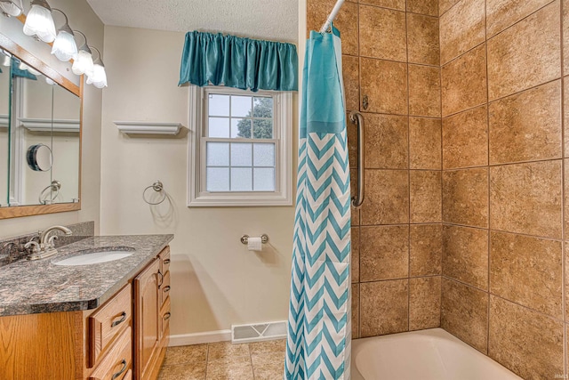 bathroom featuring a textured ceiling, vanity, tile patterned floors, and shower / bath combination with curtain