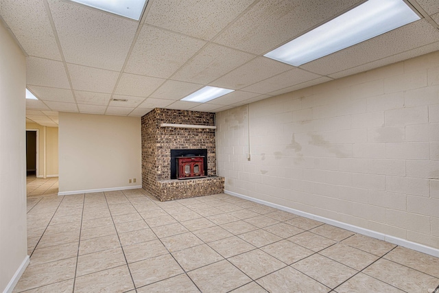 unfurnished living room with a brick fireplace, light tile patterned flooring, and a paneled ceiling