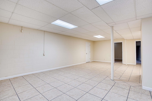 basement featuring a drop ceiling and light tile patterned floors