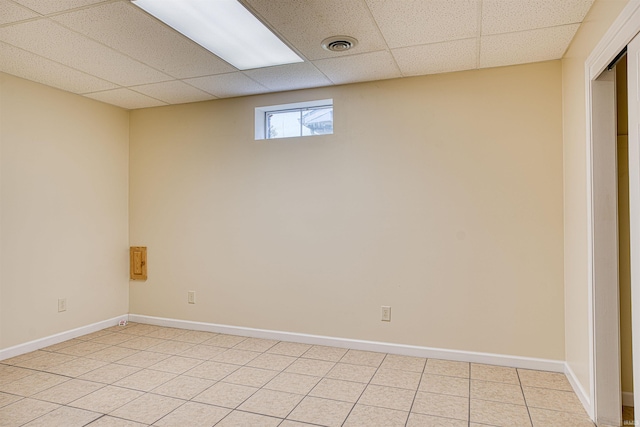 interior space with a drop ceiling and light tile patterned flooring