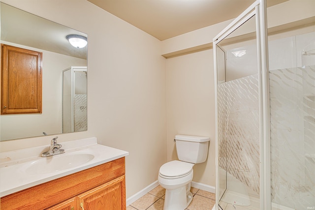 bathroom featuring vanity, a shower with shower door, toilet, and tile patterned flooring