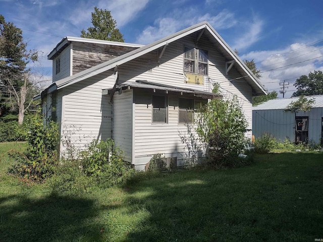 view of side of property with a storage shed and a yard