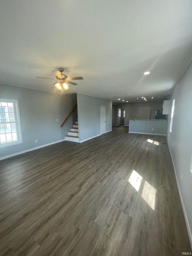 unfurnished living room with ceiling fan and dark hardwood / wood-style floors