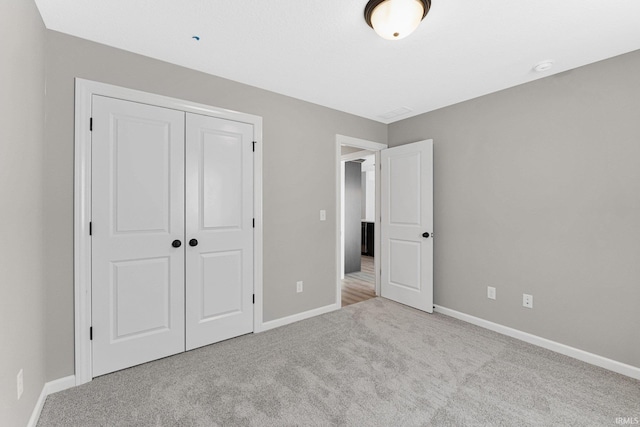 unfurnished bedroom with a closet and light carpet