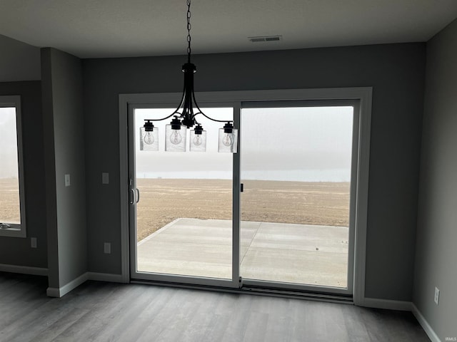 interior space featuring an inviting chandelier and hardwood / wood-style flooring