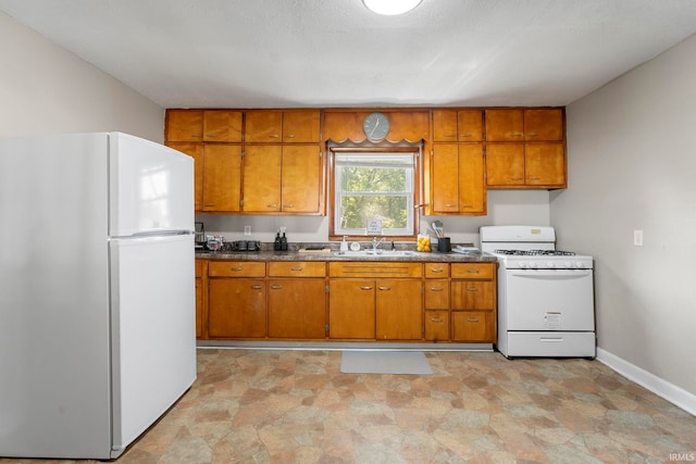 kitchen featuring white appliances, a textured ceiling, and sink