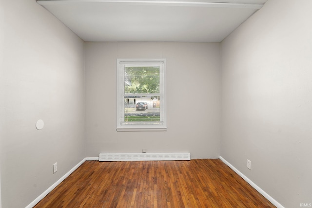 empty room with hardwood / wood-style flooring and baseboard heating