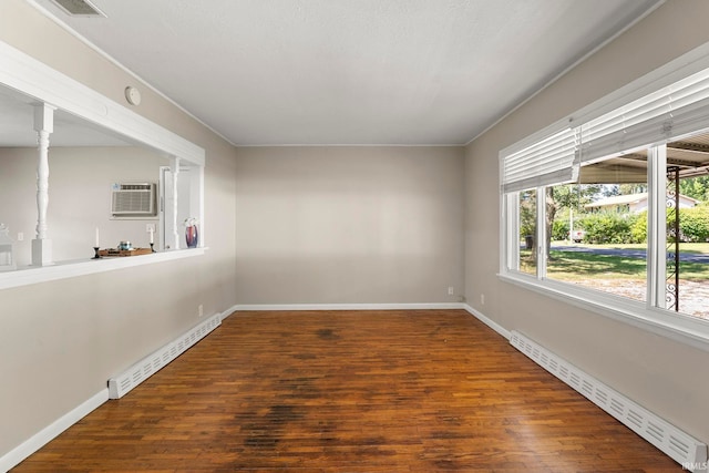 unfurnished room with dark wood-type flooring, a wall unit AC, and a baseboard radiator