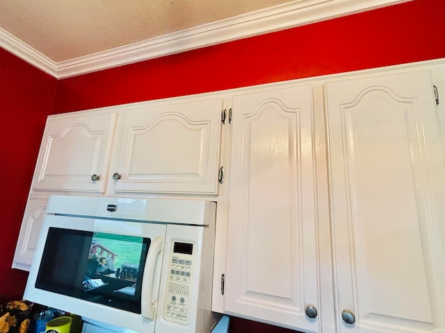 interior details featuring crown molding and white cabinets