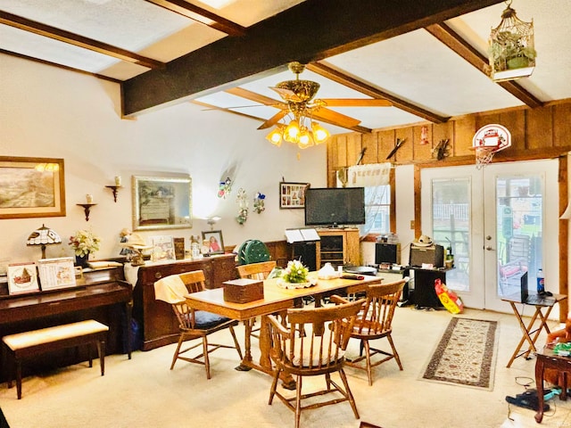 carpeted dining space with french doors, beam ceiling, and ceiling fan