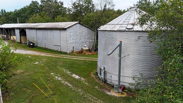 view of side of home with a lawn and a storage unit