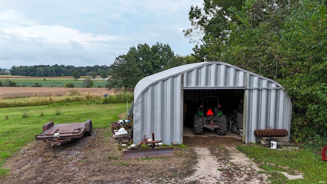 view of outdoor structure featuring a rural view and a lawn