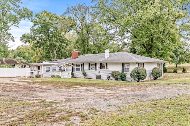 back of property with a lawn and central AC