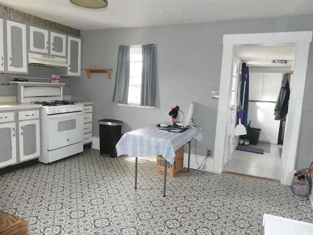 kitchen with white gas range and white cabinetry