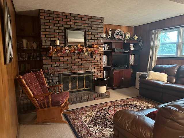 living room with a textured ceiling, wood walls, light colored carpet, and a brick fireplace