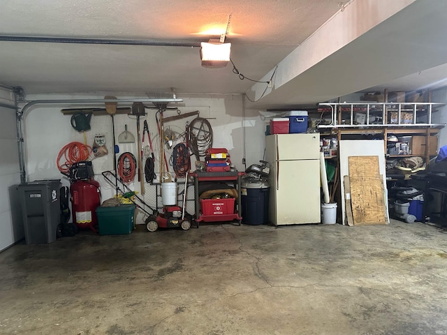 garage featuring a garage door opener and white fridge