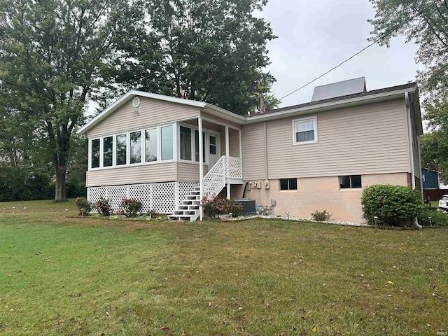 back of house featuring a lawn, central AC, and a sunroom