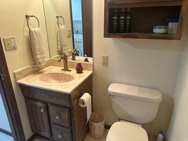 bathroom featuring washer / clothes dryer, vanity, and toilet