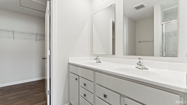 bathroom with wood-type flooring, vanity, and an enclosed shower