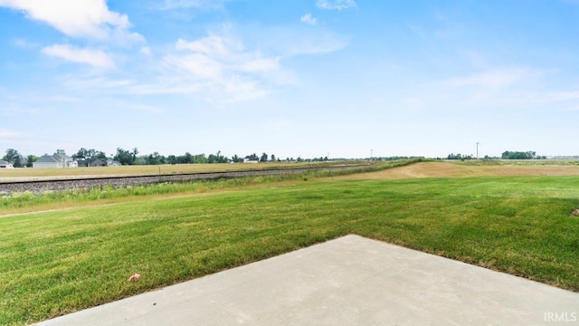 view of yard with a rural view and a patio