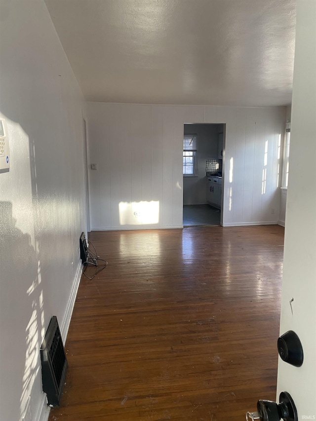 unfurnished living room with hardwood / wood-style floors and baseboards