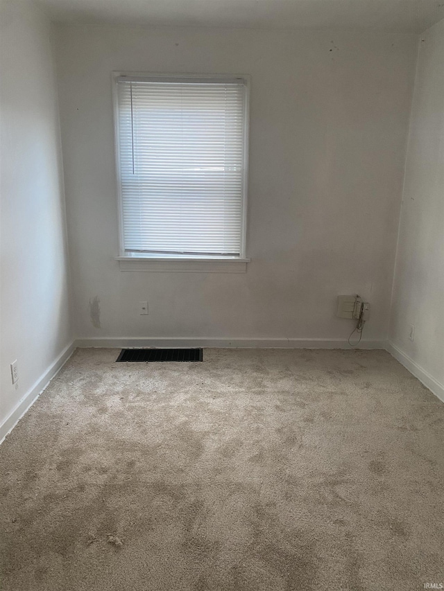 spare room with visible vents, baseboards, and carpet floors