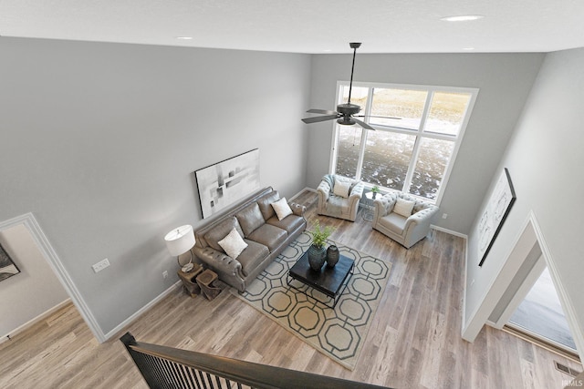 living room with ceiling fan and light wood-type flooring