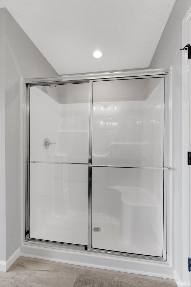 bathroom featuring a shower with shower door and hardwood / wood-style floors