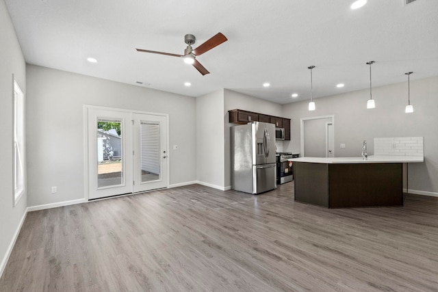 kitchen featuring pendant lighting, stainless steel appliances, wood-type flooring, dark brown cabinets, and ceiling fan