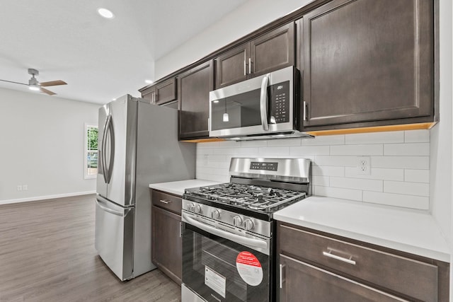 kitchen with ceiling fan, stainless steel appliances, dark brown cabinets, and light hardwood / wood-style flooring