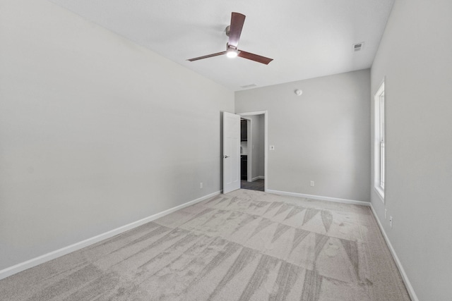 empty room with ceiling fan and light carpet